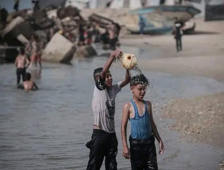 تقرير: الغزيون يُطفئون حرارة أجسادهم المنهكة بسكب الماء البارد والسباحة في البحر