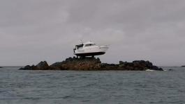 سر ظهور قارب فوق الصخور في عرض البحر بجزيرة القنال الإنجليزية