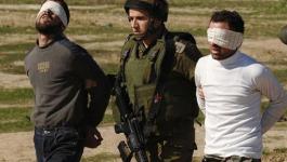جندي اسراائيلي أثناء اعتقاله شابين فلسطينيين في الضفة 
