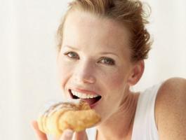 Portrait-of-a-young-woman-eating-a-croissant-939929-980x490