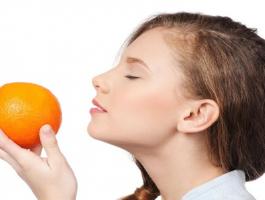 woman-smelling-orange-fruit-jpg-36056014433824142