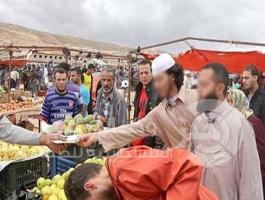 عناصر من داعش أثناء توزيع منشوراتها على الأهالي في أسواق درنة