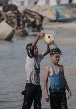 تقرير: الغزيون يُطفئون حرارة أجسادهم المنهكة بسكب الماء البارد والسباحة في البحر