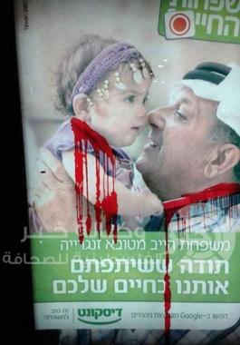 رسم خطوط بلون الدم على لافتة تحمل صورة اب عربي وطفلة وسط تل ابيب