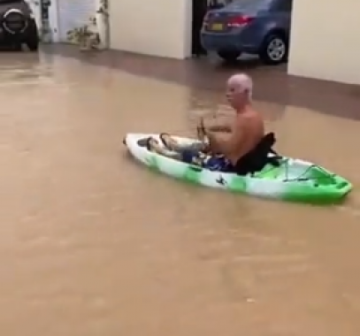 رجل يتجول بزورق مطاطى فى شوارع عمان بعد الإعصار شاهين