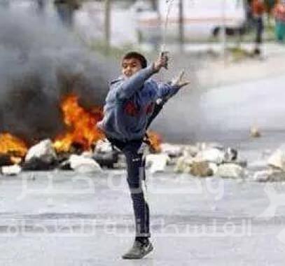 طفل فلسطيني يلقي الحجارة 