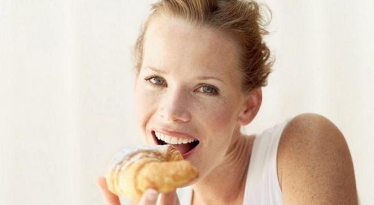 Portrait-of-a-young-woman-eating-a-croissant-939929-980x490