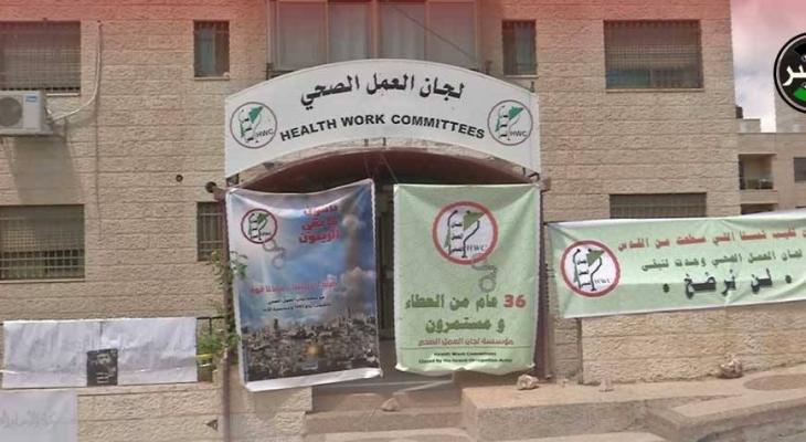 مُلثمون بالكوفية الفلسطينية يُعيدون فتح مقر لجان العمل الصحي في رام الله.