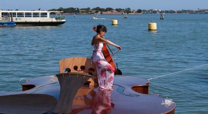 عزف موسيقى على متن قارب بشكل آلة كمان
