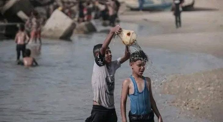 تقرير: الغزيون يُطفئون حرارة أجسادهم المنهكة بسكب الماء البارد والسباحة في البحر