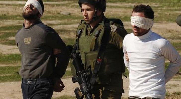 جندي اسراائيلي أثناء اعتقاله شابين فلسطينيين في الضفة 