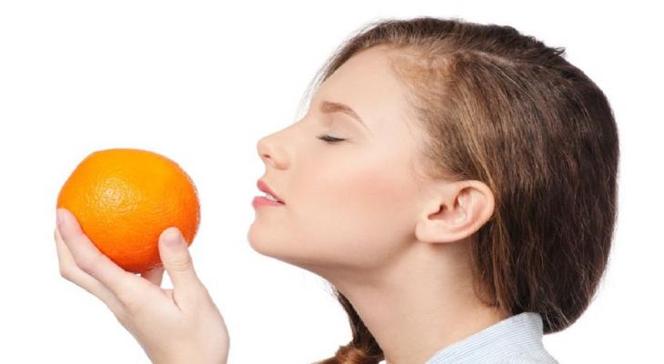 woman-smelling-orange-fruit-jpg-36056014433824142