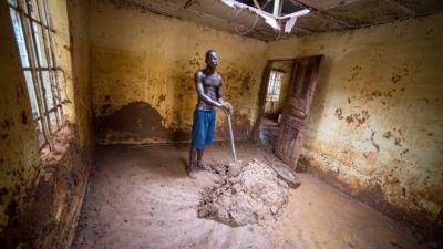 _97506127_abdulmansaray'sneighbourhelpshimcleanouthishouse.theholethroughwhichabdulescapedisvisibleintheroof.jpg